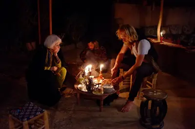 a group of women sitting around a table with candles at Dar Sidi Bounou in Mhamid