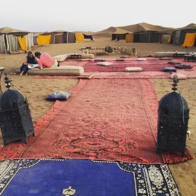 a group of people sitting on a red and blue carpet at Dar Sidi Bounou in Mhamid