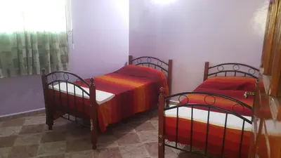 a bedroom with two beds with red and orange sheets at Bassatine appartement in Meknès