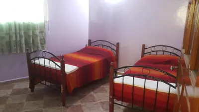 two twin beds in a room with a window at Bassatine appartement in Meknès