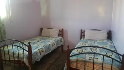 two twin beds in a room withthritisthritisthritisthritisthritisthritisthritisthritisthritis at Bassatine appartement in Meknès