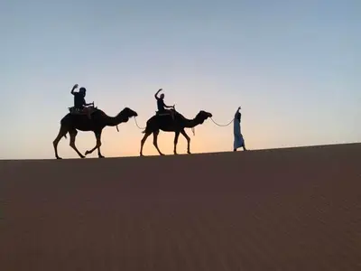 two people riding on horses in the desert at voyageur m'hamid Ghislaine in Tâlhâ