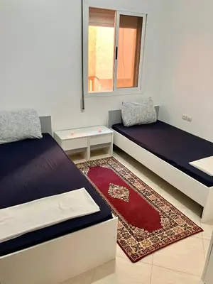 a room with two beds and a window at WiFi & Smart TV & Netflix & Free Parking & Full Kitchen & Heating & Washing Machine in Khemisset