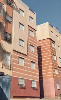 a tall brick building with windows on the side of it at WiFi & Smart TV & Netflix & Free Parking & Full Kitchen & Heating & Washing Machine in Khemisset