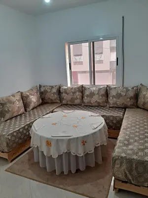 a living room with a couch and a table at WiFi & Smart TV & Netflix & Free Parking & Full Kitchen & Heating & Washing Machine in Khemisset