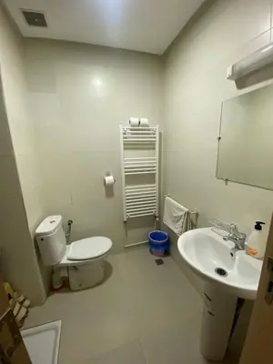 a white bathroom with a toilet and a sink at Cedar Peak Residence in Ifrane
