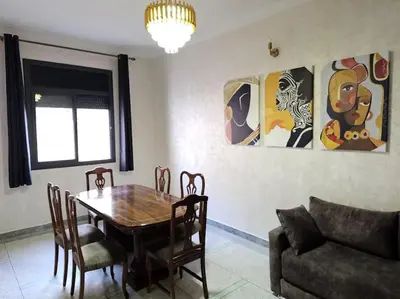 a dining room with a table and chairs and a couch at Superbe maison près de la gare de train in Fès