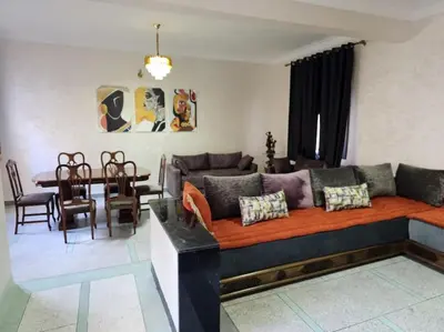 a living room with a couch and a dining room at Superbe maison près de la gare de train in Fès