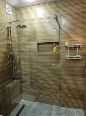 a shower with a glass door in a bathroom at Superbe maison près de la gare de train in Fès