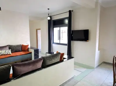 a living room with a couch and a tv at Superbe maison près de la gare de train in Fès