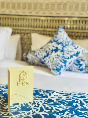 a hotel room with a sign on a bed at Riad Zawiyat Fes in Fès