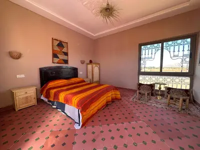 a bedroom with a large bed and a window at Dar Tiniri - Guest House - Zagora in Arhla Ou Drar