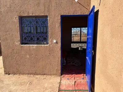 a blue door leading into a building with a window at Dar Tiniri - Guest House - Zagora in Arhla Ou Drar