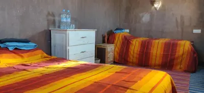 a bedroom with two twin beds and a dresser at Dar Tiniri - Guest House - Zagora in Arhla Ou Drar