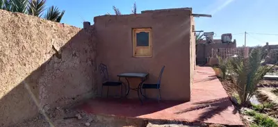 a small house with a table and chairs outside at Dar Tiniri - Guest House - Zagora in Arhla Ou Drar