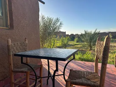 a black table and chairs on a patio at Dar Tiniri - Guest House - Zagora in Arhla Ou Drar