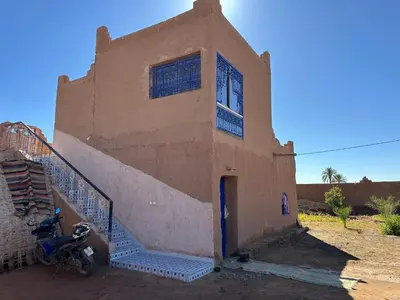 a building with a motorcycle parked in front of it at Dar Tiniri - Guest House - Zagora in Arhla Ou Drar