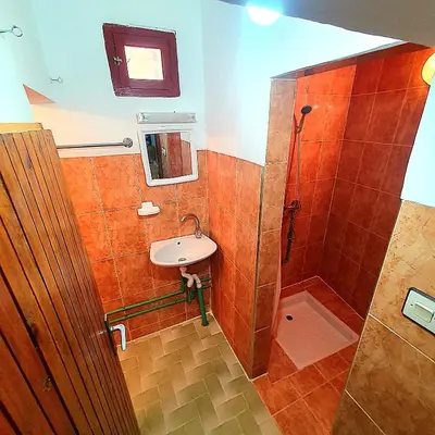 a small bathroom with a sink and a shower at Riad Taourirte in Tinerhir