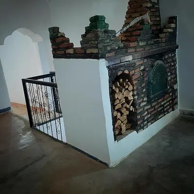 a brick fireplace with a gate next to it at Riad Taourirte in Tinerhir