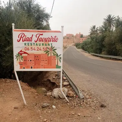 a sign sitting on the side of a road at Riad Taourirte in Tinerhir