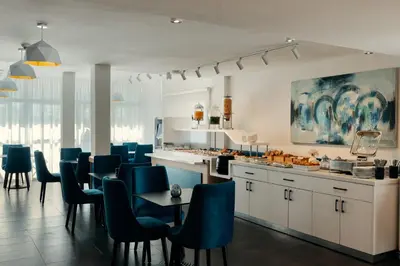 a kitchen with blue chairs and a dining room at MIA Urban Fès in Fès