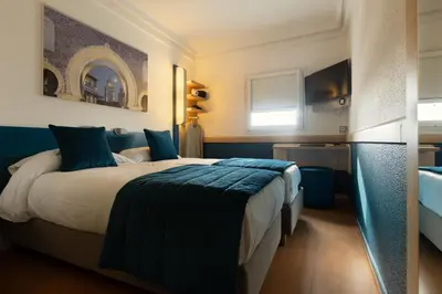 a bedroom with a large bed with blue pillows at MIA Urban Fès in Fès