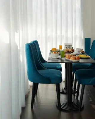 a dining table with blue chairs and food on it at MIA Urban Fès in Fès