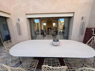 a white table with chairs and a vase on it at Luxueuse villa contemporaine KIMANU à 20 min de Marrakech in Marrakech