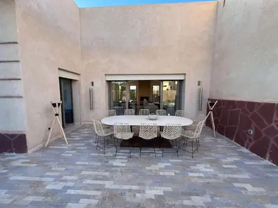 a patio with a table and chairs in a building at Luxueuse villa contemporaine KIMANU à 20 min de Marrakech in Marrakech