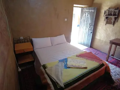 a bedroom with a bed and a door to a window at Auberge Dar Lajdoud in Tafraoute Sidi Ali