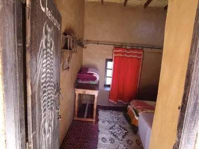 a small room with a red curtain and a window at Auberge Dar Lajdoud in Tafraoute Sidi Ali