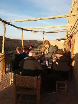 a group of people sitting at a table on a balcony at Maison Chez Lahcen - Akka Nait Sidi - Tissint in Tissint