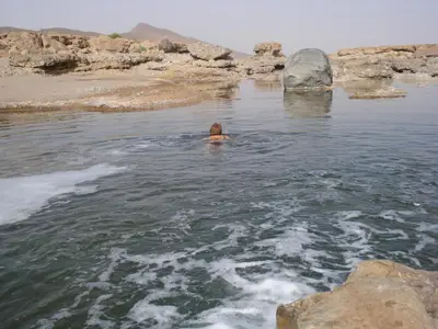 a man swimming in a body of water at Maison Chez Lahcen - Akka Nait Sidi - Tissint in Tissint
