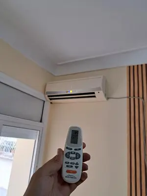 a person holding a remote control in a room at Appartement Atlas City Center in Fès