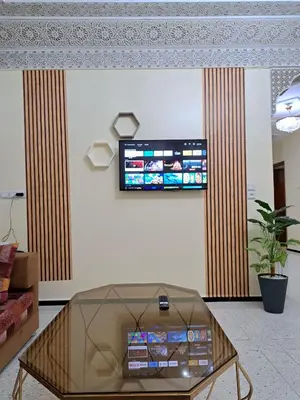 a living room with a tv on a wall at Appartement Atlas City Center in Fès