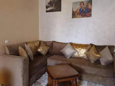 a living room with a brown couch with gold pillows at Maison Samy in Ifrane