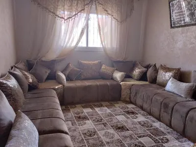 a living room with a large couch and a window at Maison Samy in Ifrane