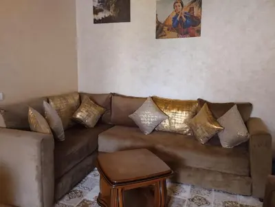 a living room with a brown couch with gold pillows at Maison Samy in Ifrane