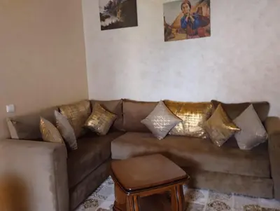 a living room with a brown couch with gold pillows at Maison Samy in Ifrane