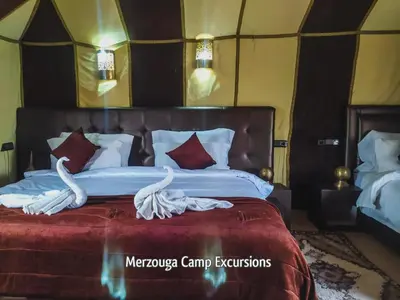 a bedroom with a large bed with swans on it at Merzouga Camp Excursions in Merzouga