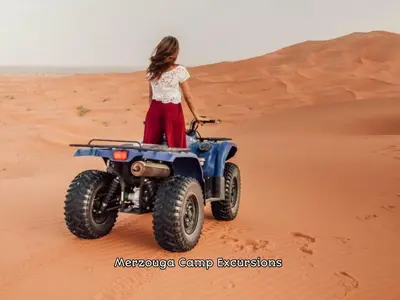 a woman standing on a wheeler in the desert at Merzouga Camp Excursions in Merzouga