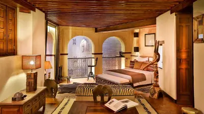 a bedroom with a bed and a couch and a table at Karawan Riad in Fès