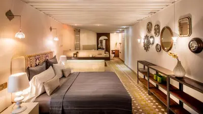 a bedroom with a large bed and a bathroom at Karawan Riad in Fès