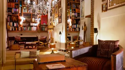 a living room with a couch and a chandelier at Karawan Riad in Fès
