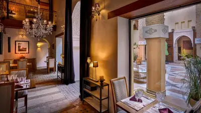 a dining room with a table and chairs in a room at Karawan Riad in Fès