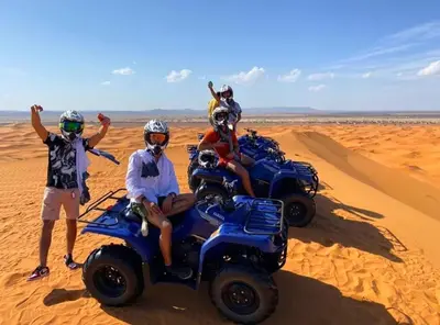 a group of people riding on atvs in the desert at Best Luxury Camp in Merzouga