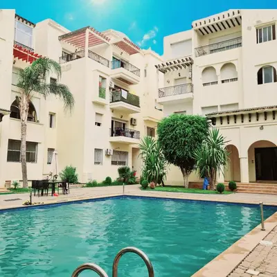 a swimming pool in front of a building at Apartment Fes Urban Elegance - Garden & Pool in Fès