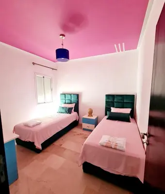 a bedroom with two beds and a purple ceiling at Apartment Fes Urban Elegance - Garden & Pool in Fès