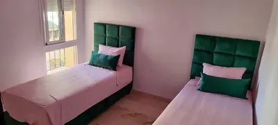 a bedroom with two beds with green headboards at Apartment Fes Urban Elegance - Garden & Pool in Fès