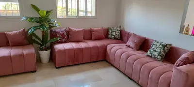 a red couch in a living room with a plant at Apartment Fes Urban Elegance - Garden & Pool in Fès